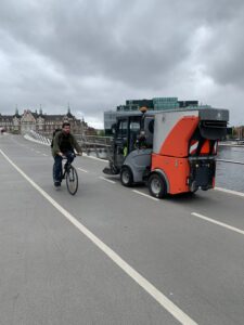 Bike Ped Bridge in Copenhagen showing a bike rider and a sweeper in the bike lane. The sweeper is scaled to fit into the bike lane perfectly.