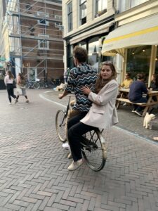 Image of person riding a bike and person sitting on the back of the bike